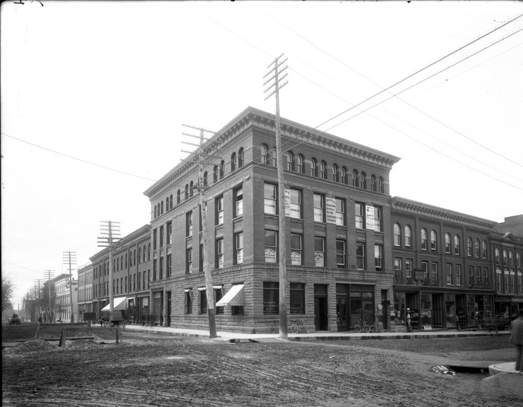 The historic commerce building-  3 story red brick building with old hydro poles and mud streets.